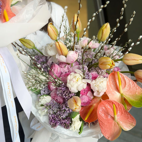 Bouquet of flowers with pink and white colors, featuring tulips and anthuriums.
