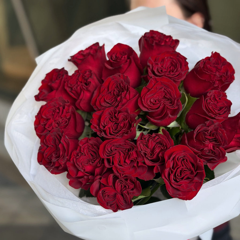 Close-up of luxury red roses bouquet wrapped in white paper