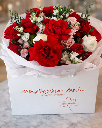 Bouquet of red, white, and pink flowers in a box with 'Mamma Mia Flower Studio' branding.