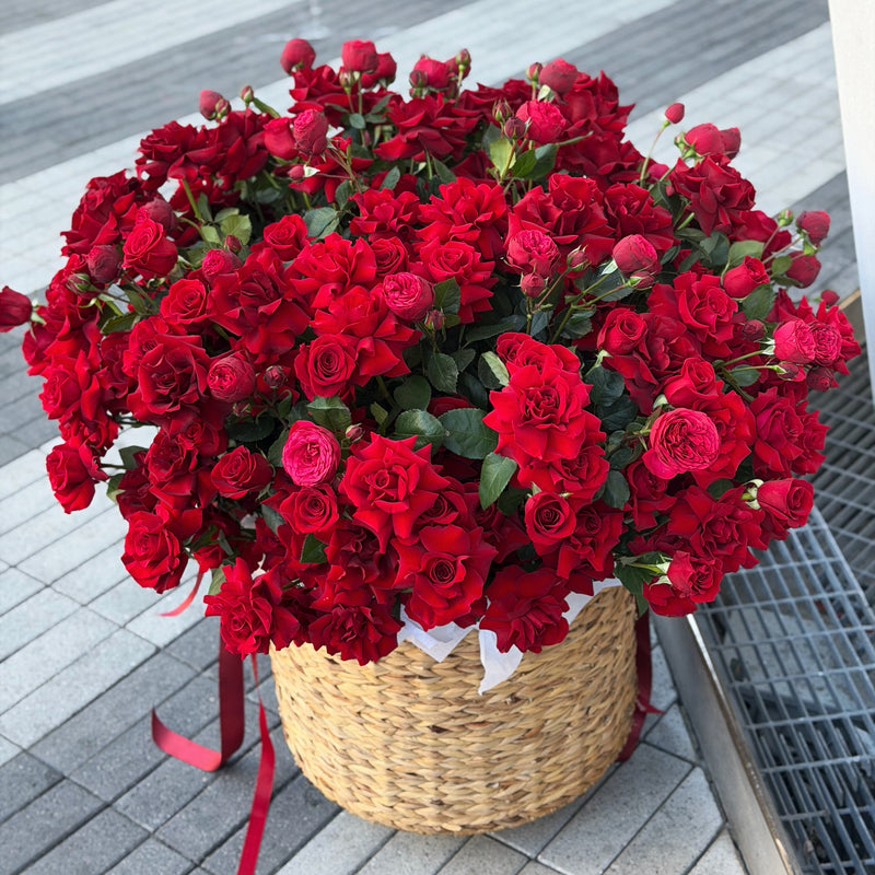 Bouquet of red flowers in a woven basket with the same day delivery in miami